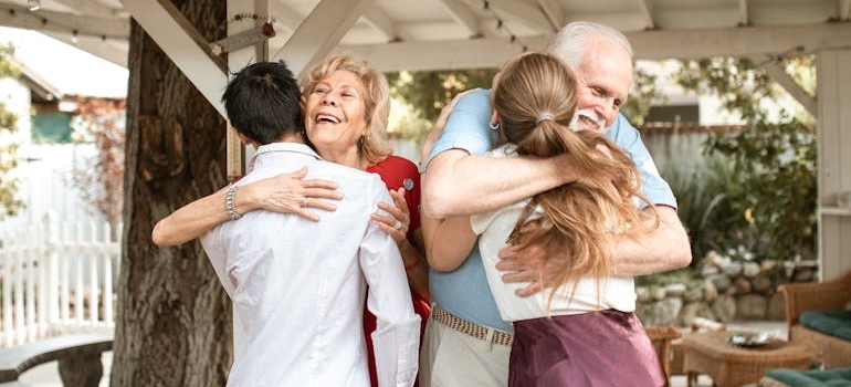 Young couple hugging and older couple.