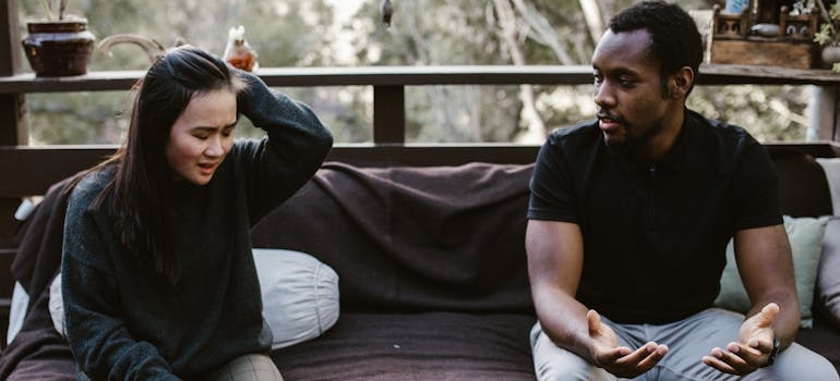 Couple sitting on the bed and working on repairing relationships after addiction.