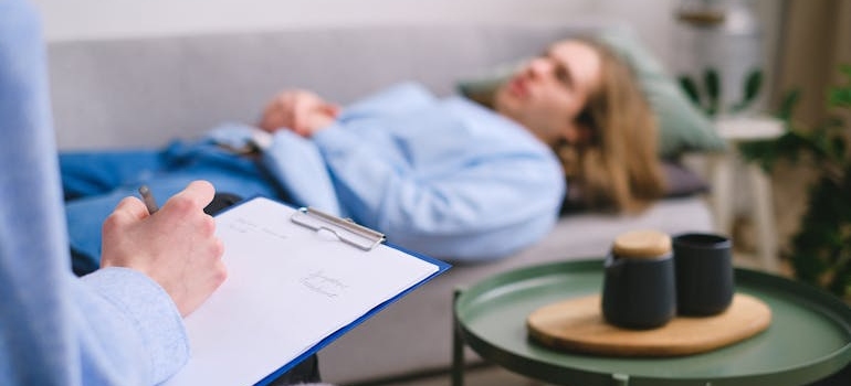 Man lying on a couch and talking to his therapist.