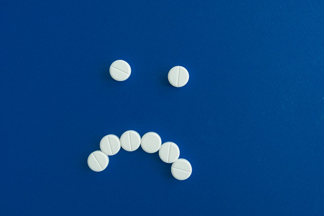 White tablets arranged in a sad face.