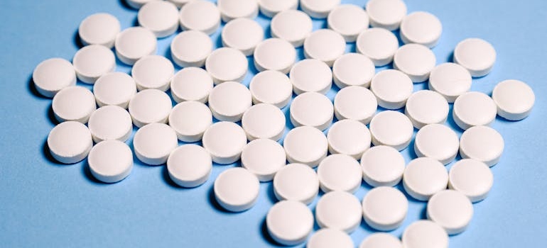 Cluster of white tablets on a blue background.