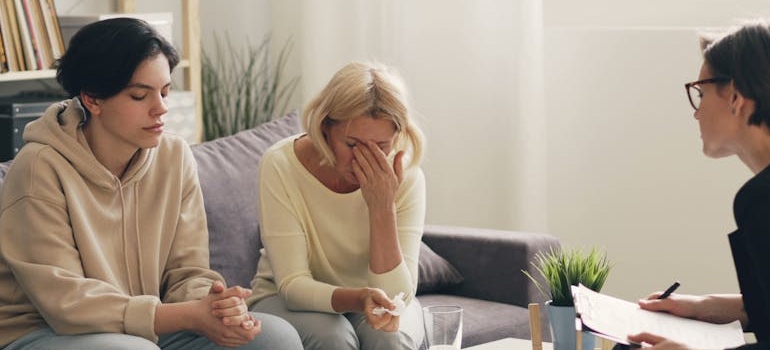 Woman and her son talking to a therapist about addiction.