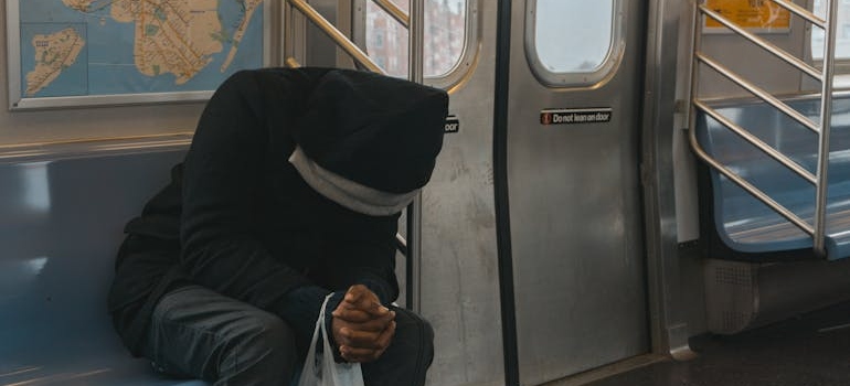 Man sitting on a subway and feeling fatigued, one of common Demerol withdrawal symptoms.