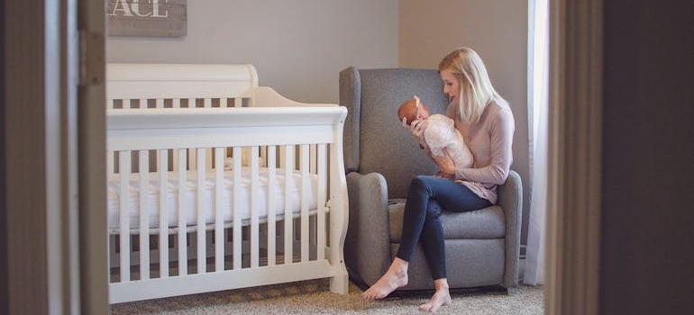 Woman sitting on an armchair and holding her baby.