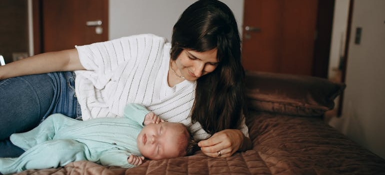 Woman lying next to her baby.