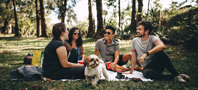 Friends sitting in the woods and having a picnic.