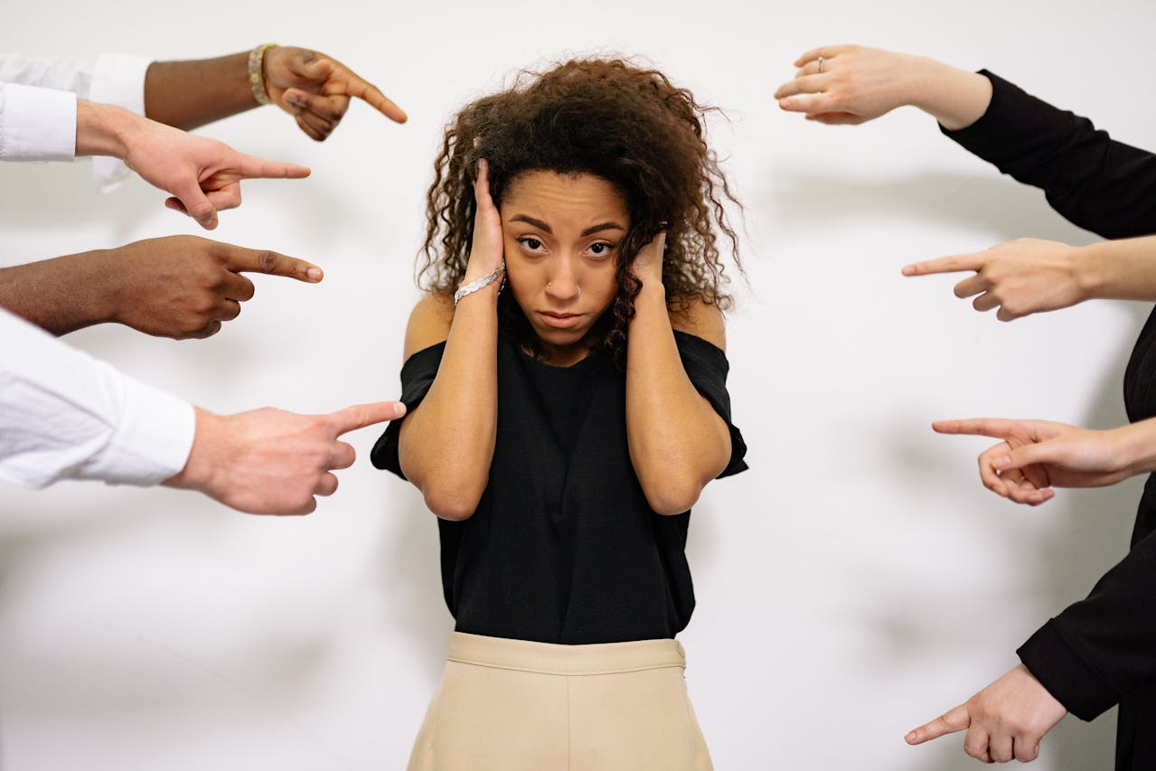 Hands pointing to a woman.