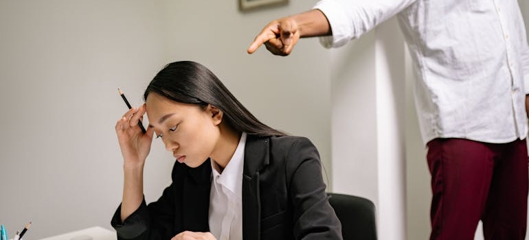 Man pointing his finger at a woman holding a pen.