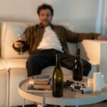 Man sitting on the couch and drinking a glass of wine.