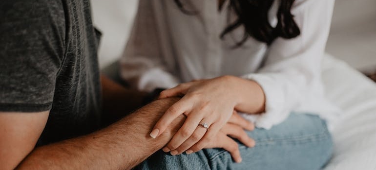 Man holding his hand on a woman's knee.