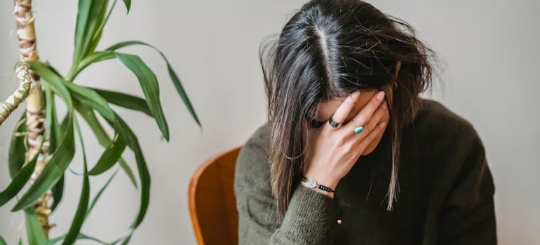 Woman covering her crying face while struggling with Ritalin side effects in females.