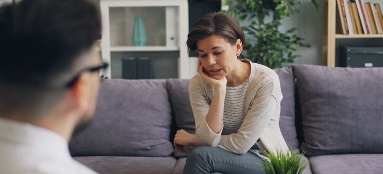 Woman discussing her struggles with mental health issues and addiction with her therapist.