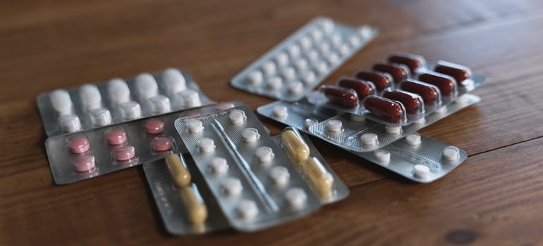 Blisters of pills on a wooden table.