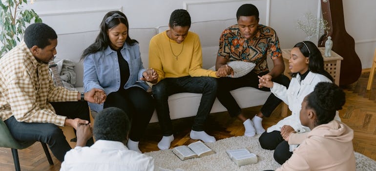 Group of people sitting in a circle and praying.