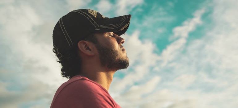 Man with closed eyes looking up at the sky.