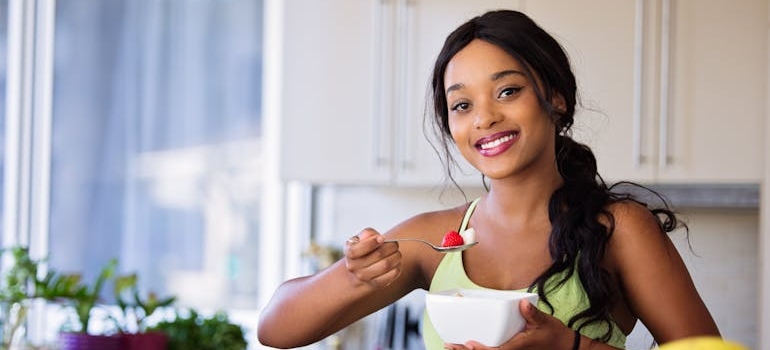 Woman eating a fruit salad after learning how to get weed out of your system.