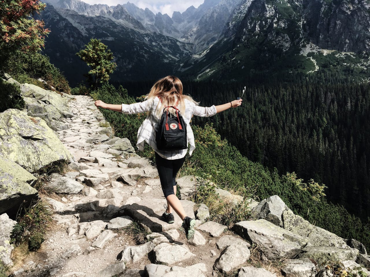 Woman hiking up a hill and attending outdoor therapy.