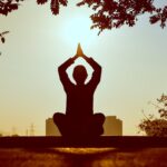 Person meditating outdoors.