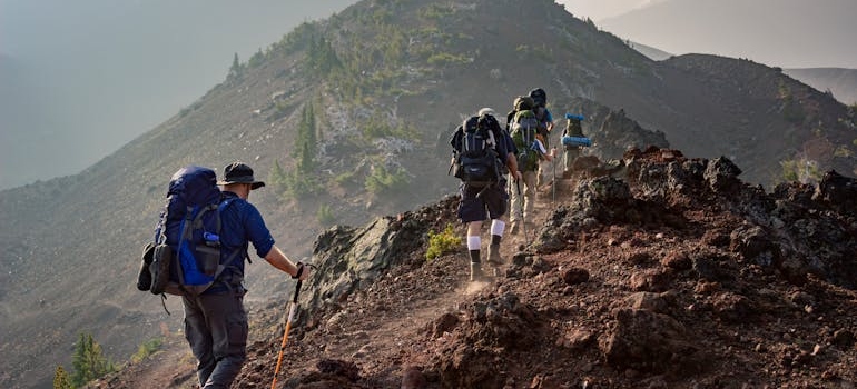 People hiking up a hill and doing outdoor therapy.