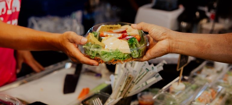 Person getting a takeout salad.