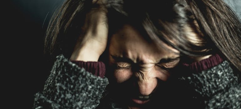 Stressed out woman holding her head in pain.