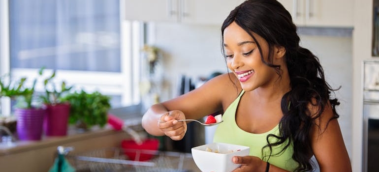 Woman eating a fruit salad out of a bowl.
