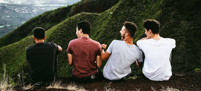 Four friends sitting on the ground and laughing.