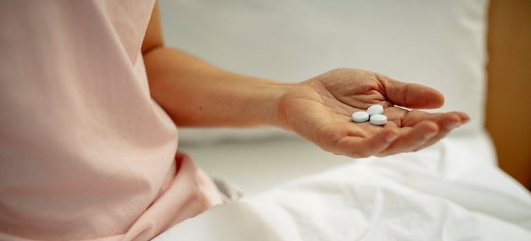 Woman holding pills in her hand.