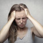 Woman having a headache because of ADHD and MDMA misuse.