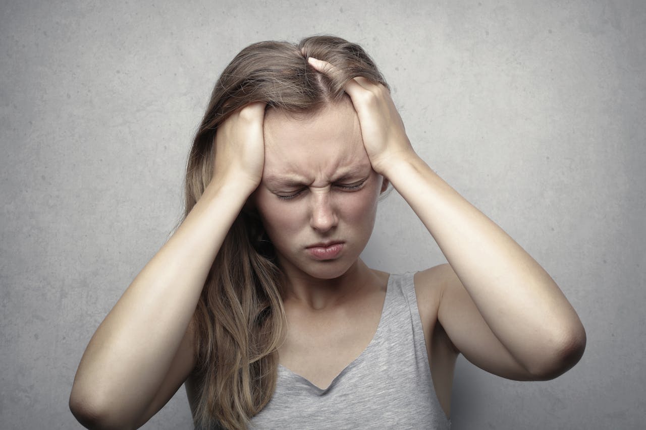 Woman having a headache because of ADHD and MDMA misuse.