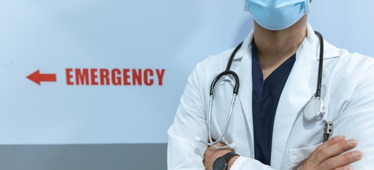 Doctor standing in front of an emergency sign.