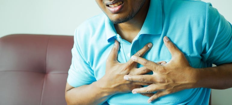 Man holding his chest in pain after ingesting Fentanyl mixed with Xylazine.