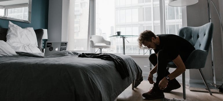 Man tying his shoes and getting ready for the day.