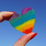Person holding a rainbow heart.