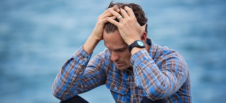 Stressed out man holding his head.