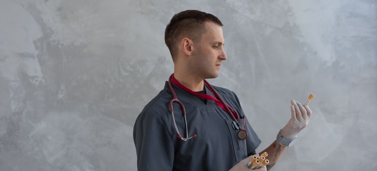 Male healthcare professional examining laboratory test samples.