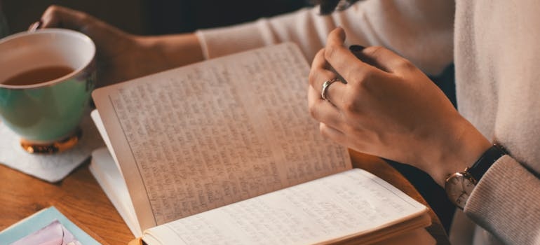 Woman drinking tea and journaling.