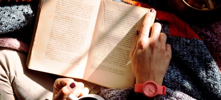 Woman reading best stress management books and drinking coffee.