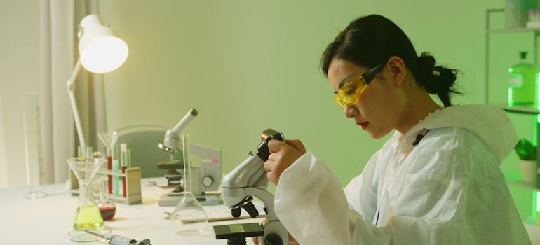 Woman inspecting genes under a microscope.