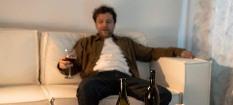 Man sitting on the couch experiencing alcohol poisoning.