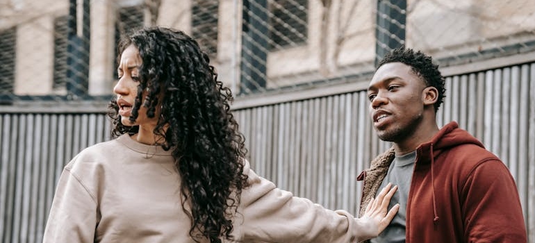 Woman pushing away a man during an argument.