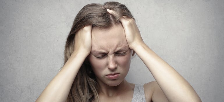 Stressed woman holding her head in pain.
