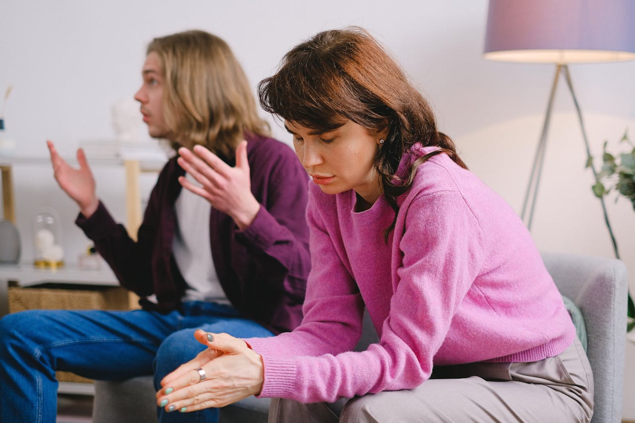 Man talking to someone while his wife is looking at the ground.