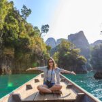 Woman sitting in a boat and enjoying sober vacations.