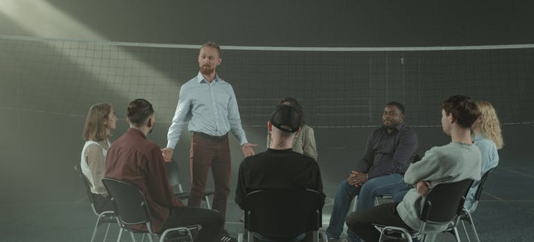 People in a support group meeting talking about genetics and addiction.