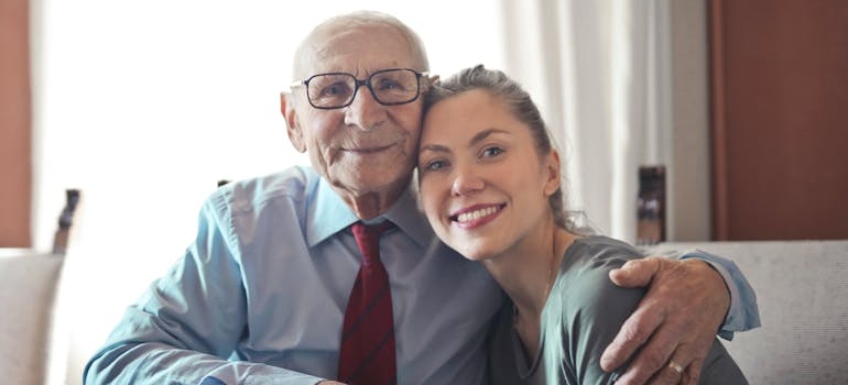 Older man hugging his granddaughter.