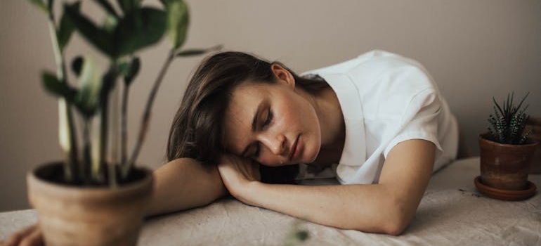 Woman falling asleep on a table.