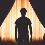 Man looking out the window while going through the stages of relapse.