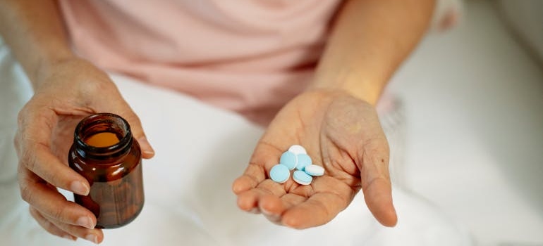 Person holding a bottle of pills.