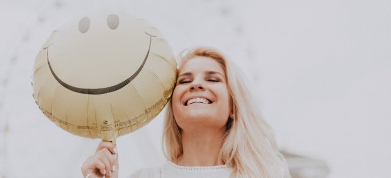 Woman smiling while holding a balloon.